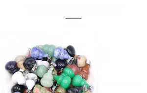Macro shot of assorted natural stone gourd pendants with silver metal clasps in a bowl