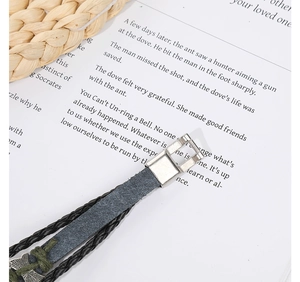 Detail of vintage layered leather bracelet with silver clasp and green accent