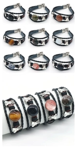 Macro view of stacked vintage leather bracelets featuring natural stones and butterfly charms