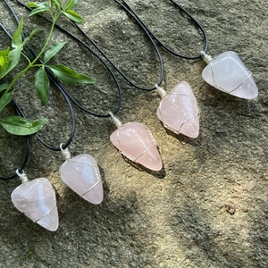 Ensemble de colliers en quartz rose naturel enveloppés de fil sur pierre