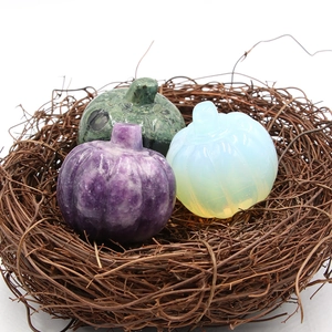 Tre zucche in pietra naturale intagliata in un nido d'uccello decorativo per Halloween