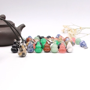 Natural gemstone gourd pendants with metal clasps on a minimalist zen white background