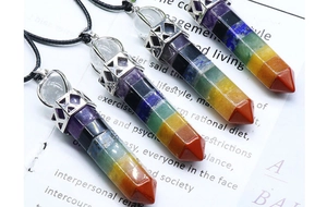 Close-up of hexagonal 7 chakra crystal stone pendants with silver metal caps and black cords