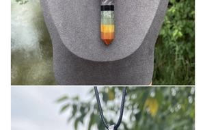 Close-up of hexagonal 7 chakra healing crystal pendant with a black woven cord necklace
