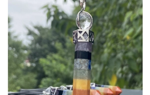 Macro shot of 7 chakra natural crystal hexagonal pendant with decorative silver metal top