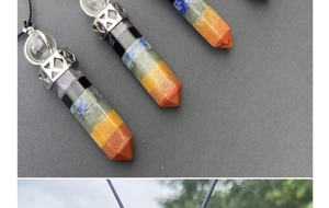 Macro detail of hexagonal 7 chakras crystal pendant with silver cap and cord