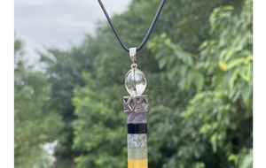Detail showing the layered colorful crystal healing wand pendant with silver geometry