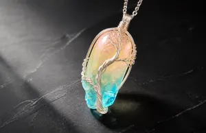 Gros plan d'un pendentif en cristal enveloppé de fil avec dégradé arc-en-ciel et arbre