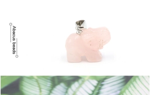 Detailopname van een geslepen rozenkwarts olifant hanger met een zilveren metalen sluiting