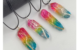Vue macro de pendentifs en cristal arc-en-ciel enveloppés de fil avec détails d'arbre de vie