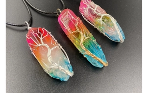 Détail du pendentif arbre de vie en cristal arc-en-ciel sur une longue chaîne pull