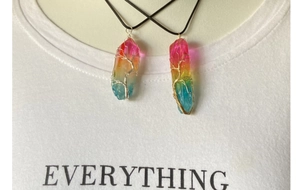 Détail macro de deux pendentifs en cristal arc-en-ciel avec enroulement de fil artisanal