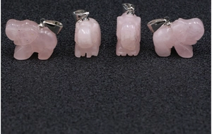 Macro detail van natuurlijke rozenkwarts olifant hangers met steentextuur en zilveren clips