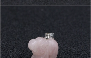 Macro-opname van handgesneden rozenkwarts olifant hanger met zilveren sluiting