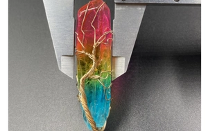 Détail d'un pendentif en cristal arc-en-ciel mesuré par un pied à coulisse