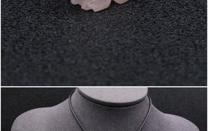 Macro-opname en modelfoto van gesneden rozenkwarts vos hanger met zwart koord ketting