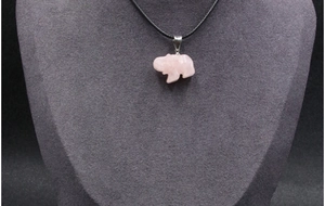 Detail van een handgesneden roze rozenkwarts olifant hanger aan een zwart koord