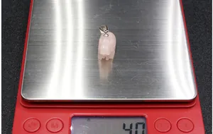 Macro-opname van 4,0 g roze rozenkwarts olifant hanger op een digitale weegschaal