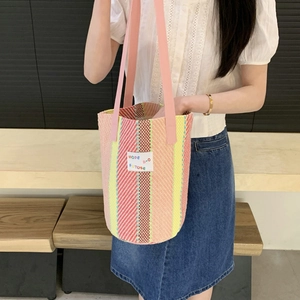 Colorful striped woven tote bag with pink leather strap and decorative logo label