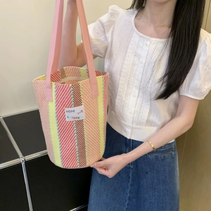 Detail of colorful woven tote bag featuring striped pattern and Hope and Future patch
