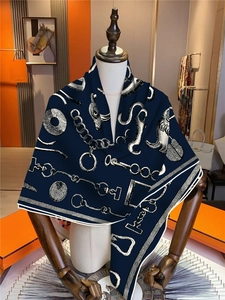 Close-up of navy blue silk square scarf featuring detailed white equestrian pattern motifs
