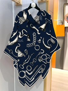 Detail of dark blue silk scarf featuring equestrian motifs on a floral brand hanger