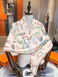 Detailed drape of a luxury horsebit pattern square scarf on a boutique display mannequin