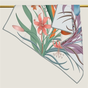 Close-up of a floral silk scarf draped over a gold rod showing fabric texture