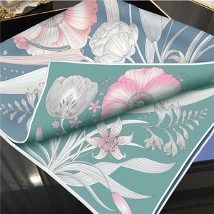 Detail view of premium twill faux silk scarf featuring vibrant blue floral patterns