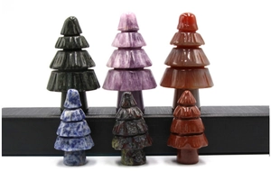 Detailed collection of six miniature natural stone Christmas trees on a black display stand