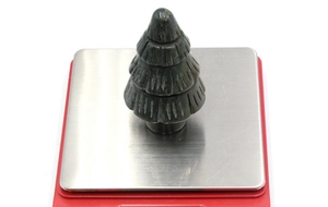 Detail of hand-carved natural stone Christmas tree showing layered texture on a scale
