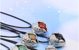 Detailed close-up of openable heart locket necklaces with angel wings and colorful beads
