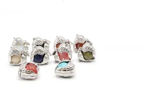 Detailed shot of engraved silver orb pendants with assorted colorful gemstone stones