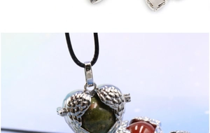 Detail of heart-shaped angel wing locket with green moss agate stone on black cord