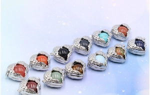 Detail of angel wing heart lockets featuring various colorful natural stone spheres