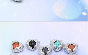 Close-up of angel wing heart locket pendant with various colored gemstone spheres