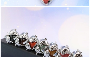 Detail of angel wing heart cage pendants with multi-color beads on a display