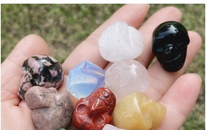 Macro detail of hand-carved natural crystal skull figurines in diverse gemstones