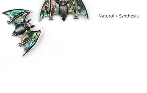 Macro detail of bat pendant showing vintage silver metal and iridescent abalone shell inlay