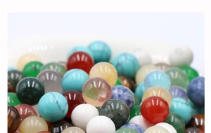 Macro shot of 10mm polished natural green aventurine and multi-colored gemstone round beads