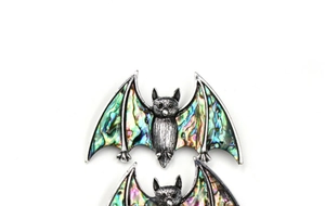 Detailed view of bat pendant featuring vibrant inlaid abalone shell on vintage silver metal