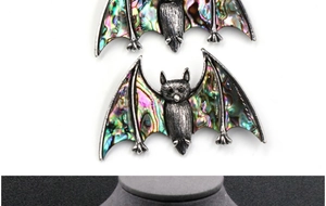 Detailed macro view of vintage gothic bat pendant featuring colorful abalone shell inlays