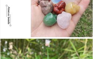 Detailed view of hand-held 1-inch natural crystal skull carvings in various semi-precious stones