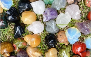 Detailed top view of various 1-inch polished natural crystal skull carvings on grass