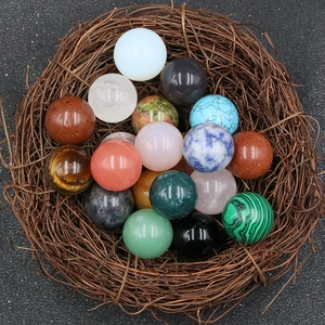 Polished 20mm multi-gemstone crystal balls displayed in a natural bird nest set