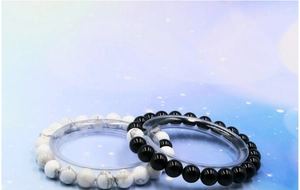Detail of 8mm white turquoise and black agate beaded bracelets for couples on clear stands