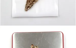 Detail eines Naturkristall-Achatanhängers mit vergoldetem Rand in Schutzverpackung