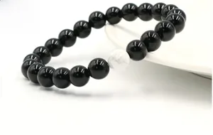 Detail of 8mm black onyx and white turquoise beads with yin yang style on a white plate