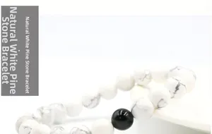 Macro shot of 8mm natural white howlite beads with marble texture and one black onyx bead