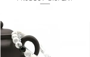 Detail of 8mm white turquoise and black onyx beaded bracelet set on dark ceramic bowl